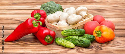 Heap of different vegetables on the wooden table.