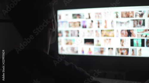 Young mand watching naked women in the computer screen photo