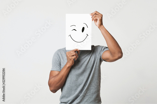 Black man holding paper with smiley face