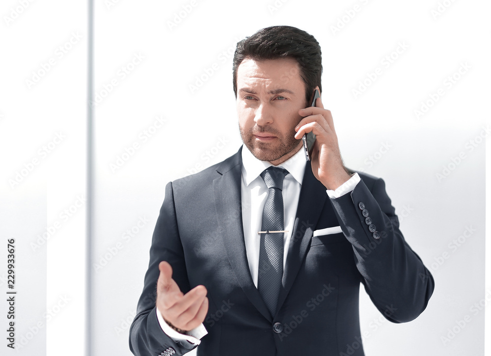 serious businessman talking on mobile phone serious businessman talking on mobile phone