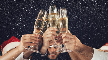 Clinking glasses of champagne in hands at New Year party