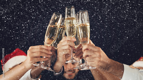 Canvas Print Clinking glasses of champagne in hands at New Year party