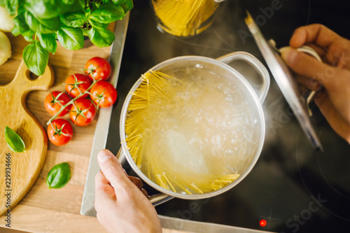 Canvas Print Man cooking pasta in boiling water