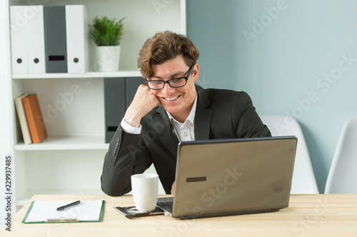 Business people, humor and fun concept - Handsome office man laughing at workplace