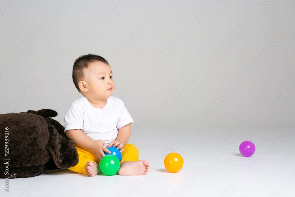 funny baby boy sitting on white background with ball funny baby boy sitting on white background with ball