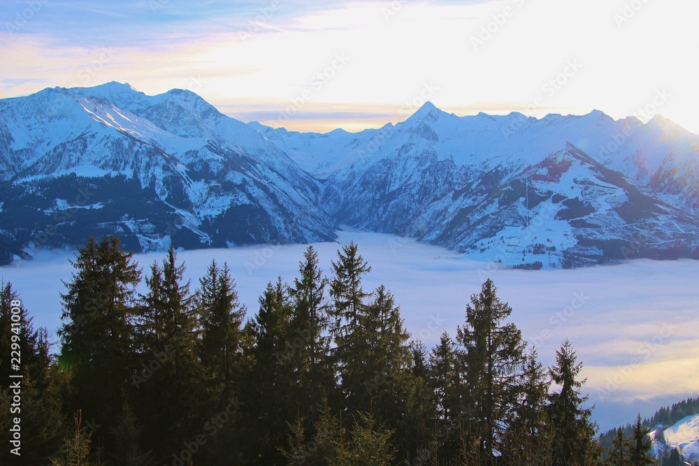View of the Hohe Tauern mountain range with mountain Kitzsteinhorn (3200 m) in the region Zell am See-Kaprun, in winter. Dense fog lies over the valley. Hohe Tauern National Park, Austria, Europe.
