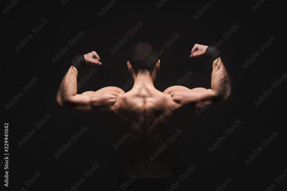 Unrecognizable man shows strong back muscles closeup Unrecognizable man shows strong back muscles closeup