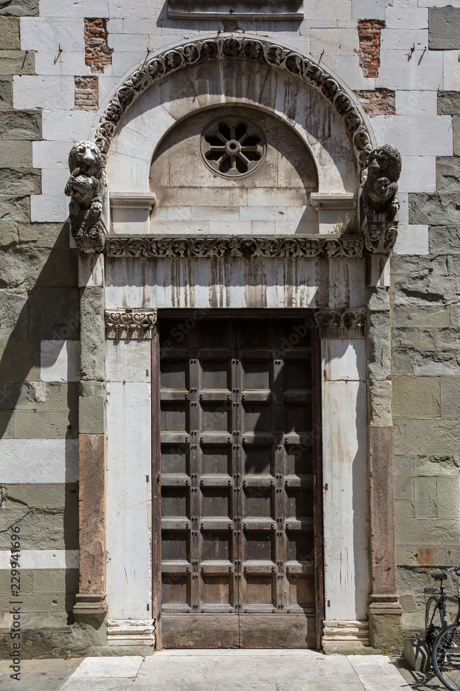 Fototapeta premium Decorative old wooden door in Lucca, Italy