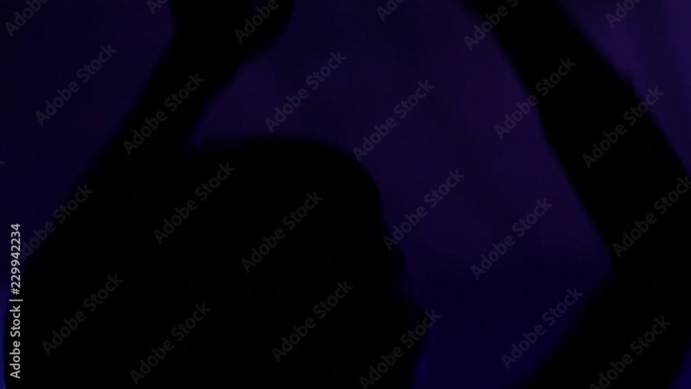 Cheerfully dancing jumping hands in air female fans at the concert lumiere