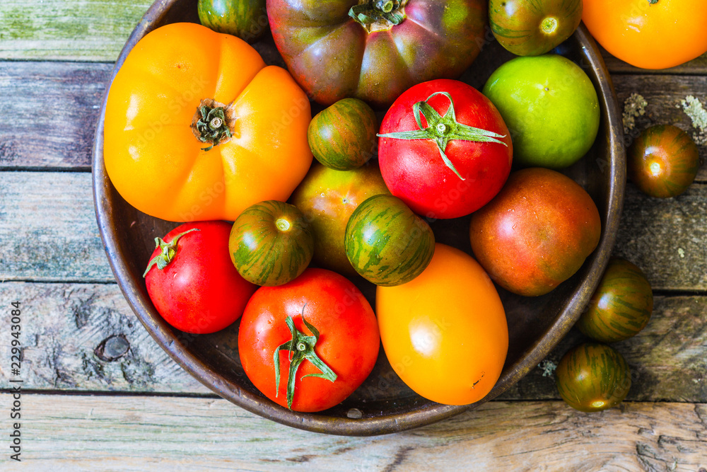 Fresh various tomatoes on rustic wooden table