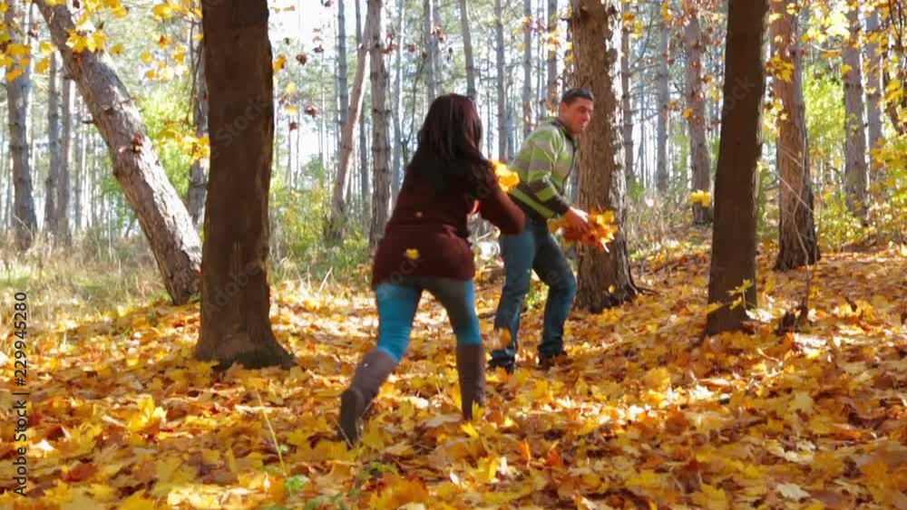 A woman and a man play with leaves. Slow motion. A woman and a man play with leaves. Slow motion.
