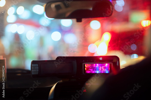 Night road view from inside taxi meter natural light street and other cars is motion blurred, traveling at night time at bangkok thailand