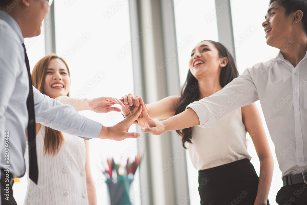 Teamwork concept. Team building meeting. Young and old business people laughing standing and join hand in office. Teamwork concept. Team building meeting. Young and old business people laughing standing and join hand in office.