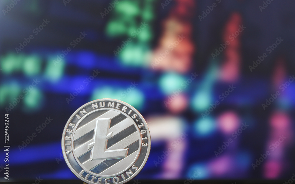 One Litecoin coin on a background of red and green stock market figures One Litecoin coin on a background of red and green stock market figures