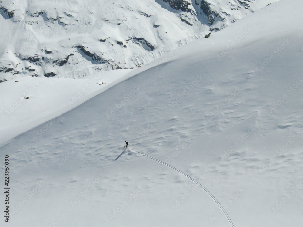 backcountry skier enjoying a deep powder ski descent in the high Alps of Switzerland in deep winter near Morteratsch