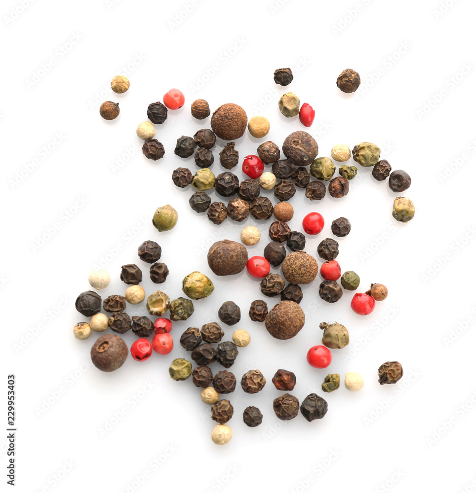 Mix of different pepper grains on white background, top view. Natural spice Mix of different pepper grains on white background, top view. Natural spice