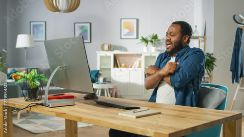 Portrait of the Shocked Handsome African American Man Sitting at His Workplace. Young Man Watching Screamers at Home. © Gorodenkoff