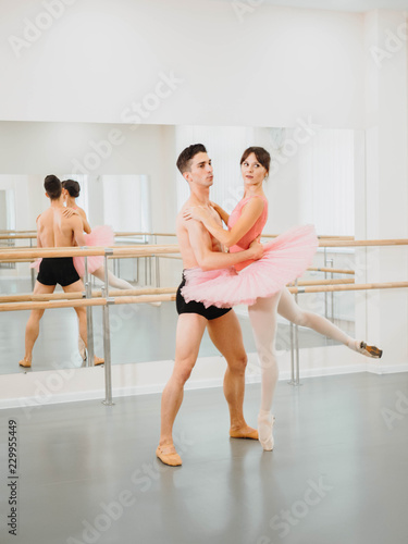 Professional, emotional ballet dancers practicing in the gym or hall with minimalism interior. Couple dancing a sensual dance before performance