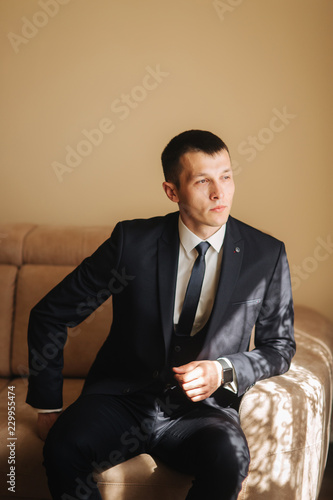 Handsome groom on his wedding day. Man getting dressed in the morning