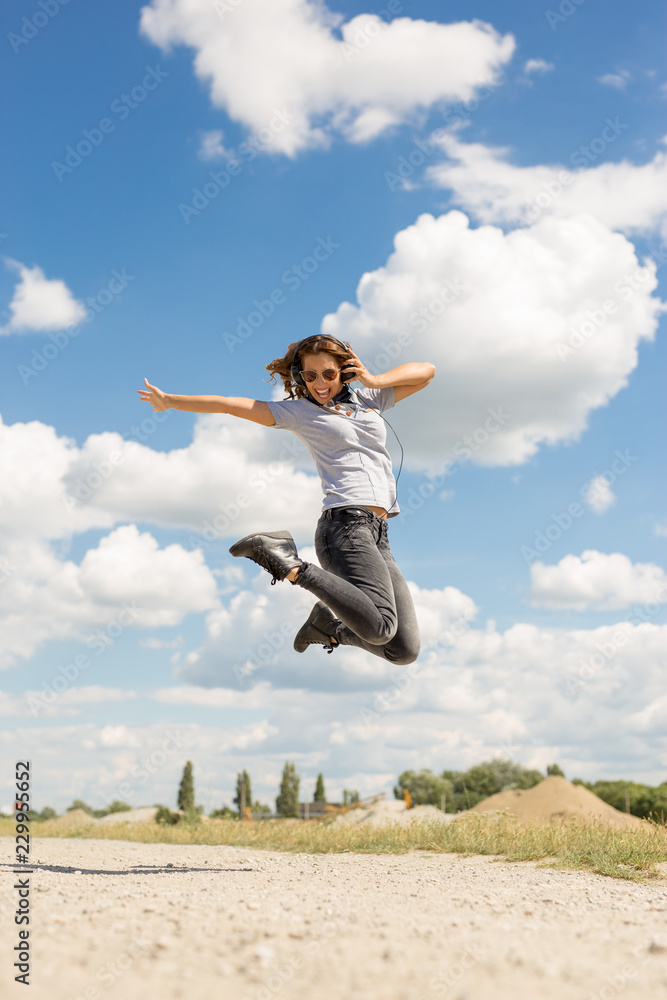 Beautiful young woman jumping in the air with headphones Beautiful young woman jumping in the air with headphones