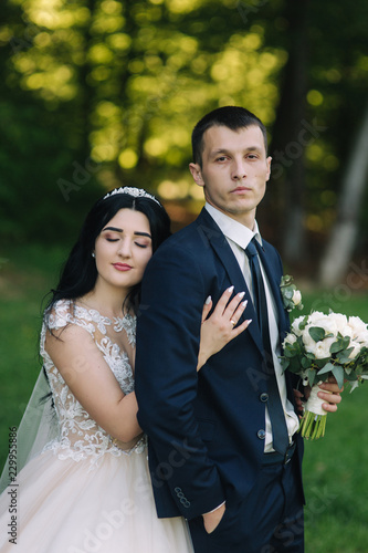 Lovely couple walkink in the park on their wedding day photo