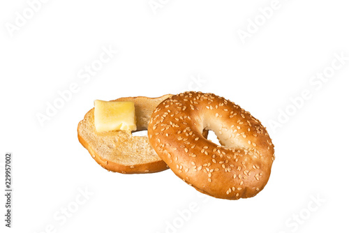Fresh sesame seed bagel bread with a piece of melted butter  isolated on a white background.