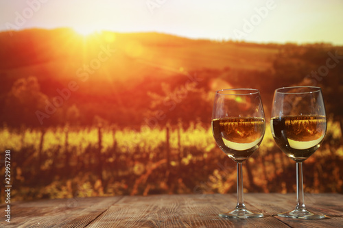Two glasses with wine on a wooden table in an autumn setting 