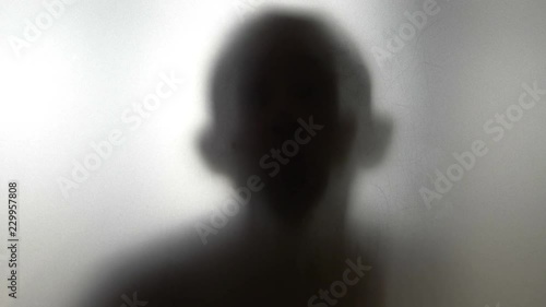 Dancing man behind frosted glass in 4k slow motion 60fps