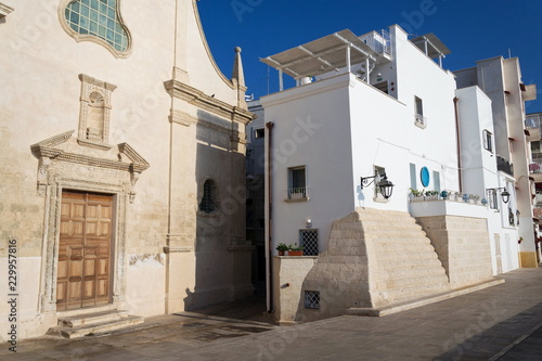 Seafront with catholic Church Chiesa San Salvatore in Monopoli, Adriatic sea, Italy, sunny summer day