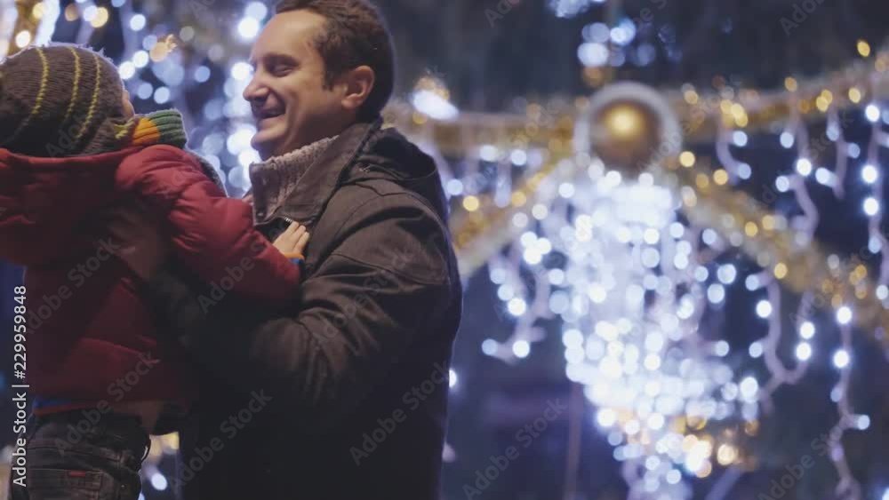 Child jumping in father arms at Christmas tree, happy winter holidays portrait Child jumping in father arms at Christmas tree, happy winter holidays portrait