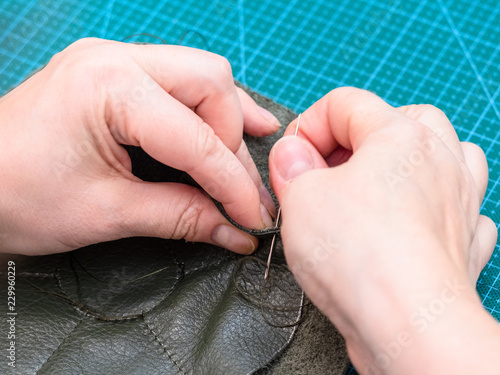 craftsman sews inner pockets of the pouch