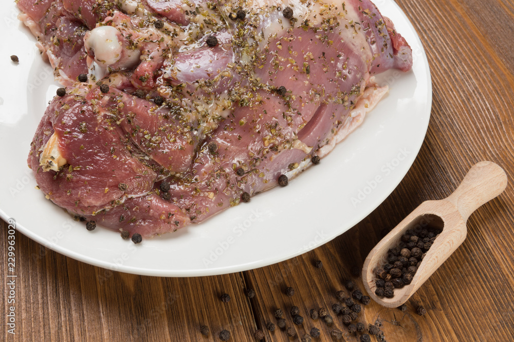 turkey meat marinated with spices, surrounded by scattered pepper peas, on wooden boards, macro photography