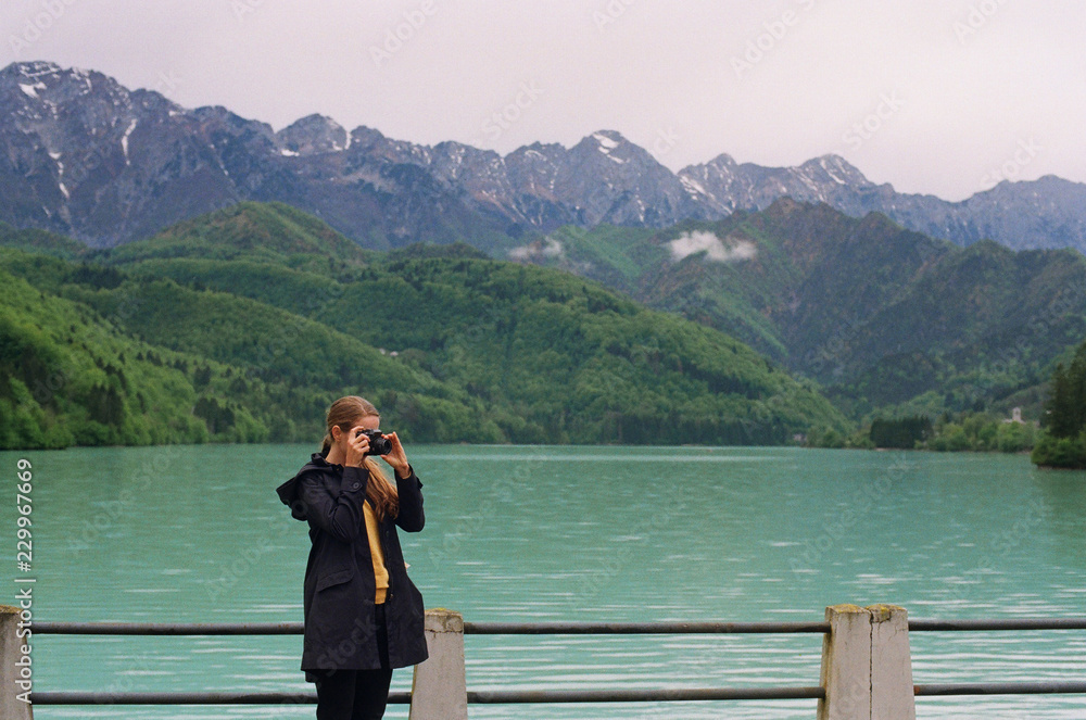 Woman taking picture in mountains Woman taking picture in mountains