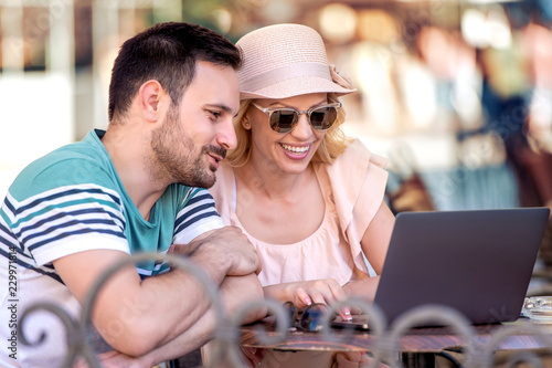 Young attractive couple having fun ,using laptop