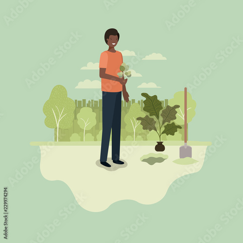 black man planting tree in the park with shovel