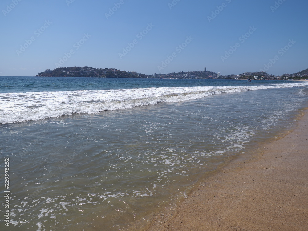Scenic scenery of sandy beach at bay of ACAPULCO city in Mexico and white waves of Pacific Ocean landscape Scenic scenery of sandy beach at bay of ACAPULCO city in Mexico and white waves of Pacific Ocean landscape
