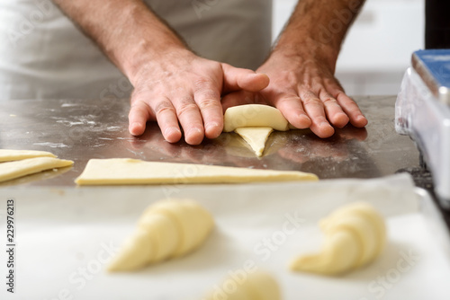 Dough triangles rolling into croissants