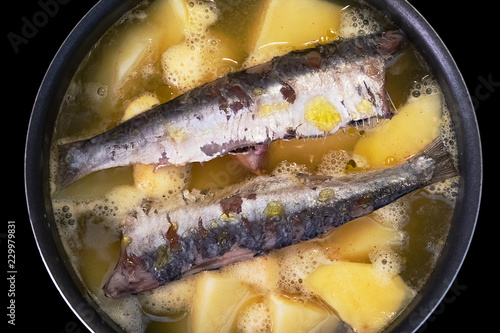 Boiling sardines with potatoes