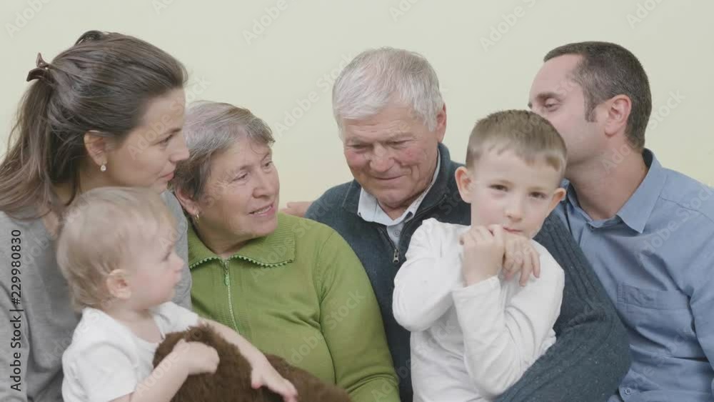 Family portrait, baby child, brother, parents and grandparents together in home Family portrait, baby child, brother, parents and grandparents together in home