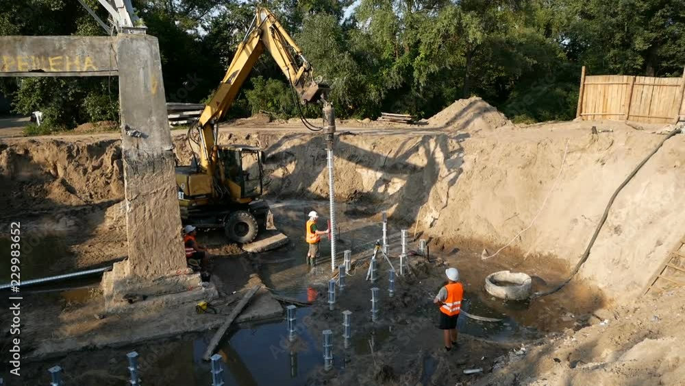 worker controls the angle at which the pile goes into the ground. construction of the building worker controls the angle at which the pile goes into the ground. construction of the building
