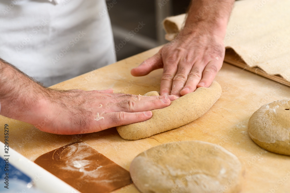 Worker is kneading dough Worker is kneading dough