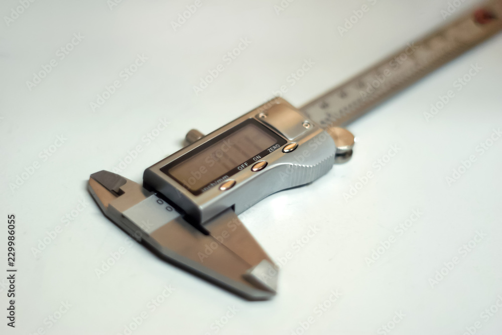 modern digital caliper on a light background, partial blur modern digital caliper on a light background, partial blur