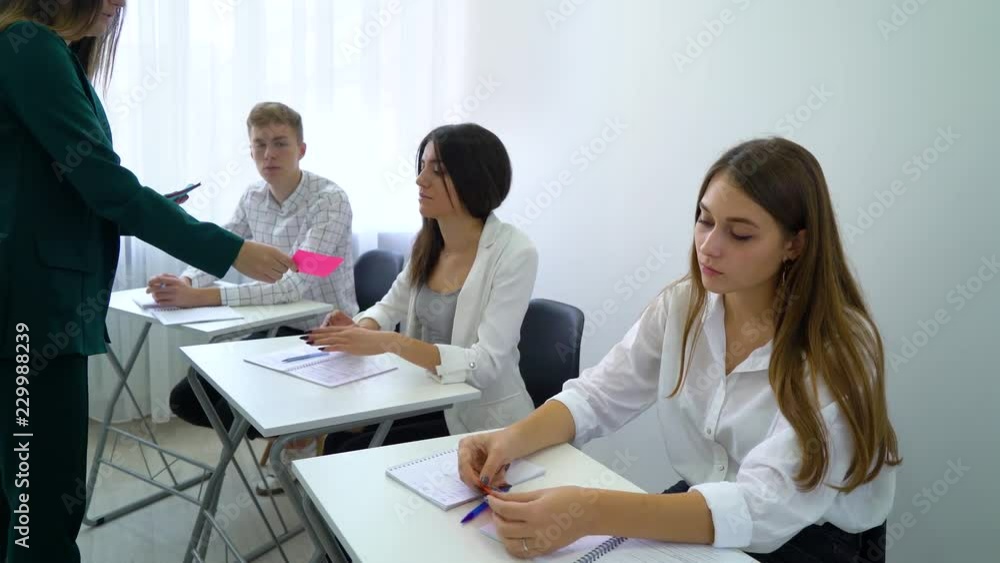 young teacher teaching students and giving task card in classroom. interactive education, practice, learning, education, knowledge, development, study concept young teacher teaching students and giving task card in classroom. interactive education, practice, learning, education, knowledge, development, study concept