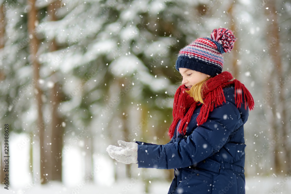 Adorable little girl having fun in beautiful winter park. Cute child playing in a snow. Adorable little girl having fun in beautiful winter park. Cute child playing in a snow.