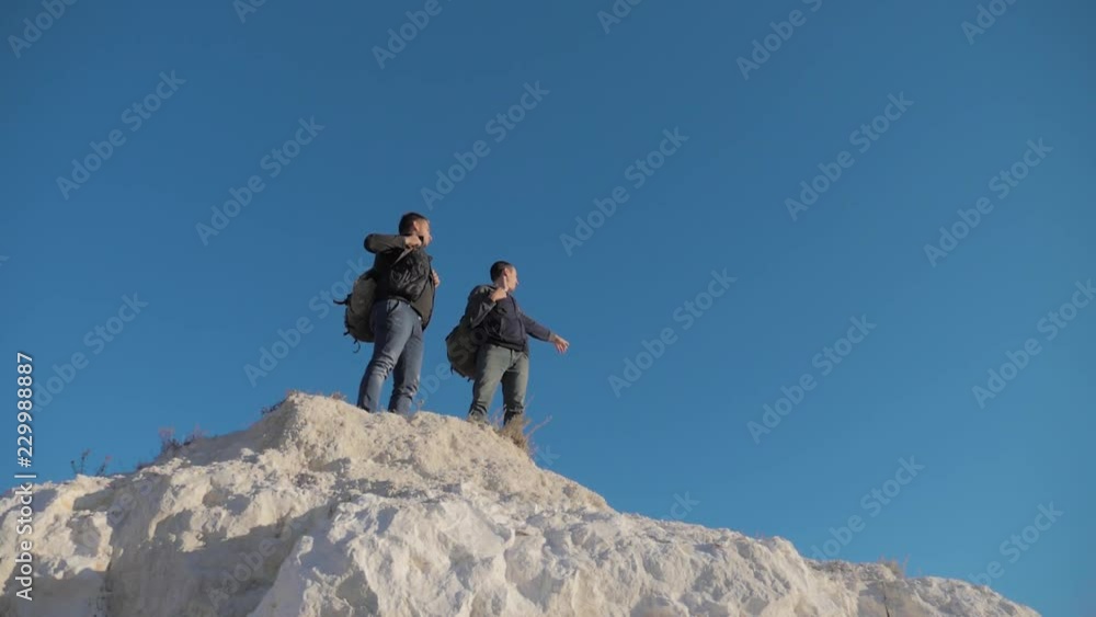 two men tourists hiking adventure climbers climb the mountain . slow motion video. hiker walking on top win victory the hill white rock. extreme outdoor lifestyle activity sport concept tourist two men tourists hiking adventure climbers climb the mountain . slow motion video. hiker walking on top win victory the hill white rock. extreme outdoor lifestyle activity sport concept tourist