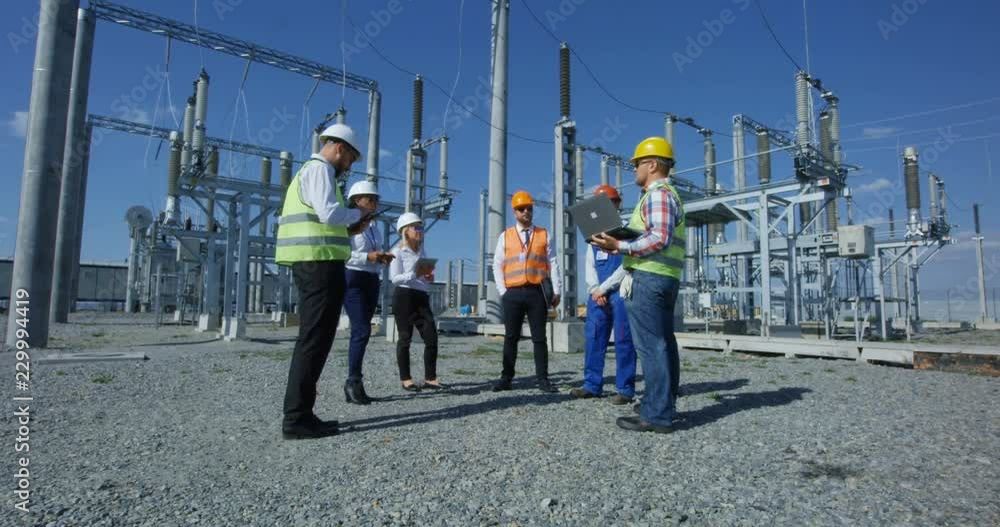 custom made wallpaper toronto digitalMedium shot of a group of electrical workers in safety vests talking to each other against the background of a transformer station