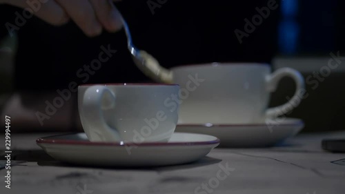 Woman hands typing on green screen mobile phone on background coffee cup on saucer standing at table in cafe. Woman using green screen smartphone. Mockup chroma key in mobile phone screen