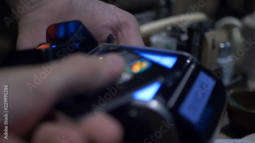 Wireless payment. Credit card payment terminal. Transfer payment. Woman paying through smart phone using NFC technology. Close up.