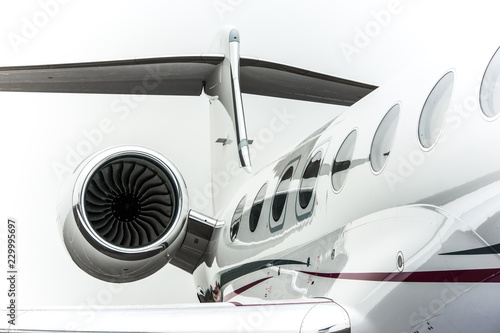 High detailed closeup view on small white private business jet windows engine