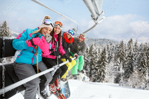 Woman in ski lift taking selfie with friends